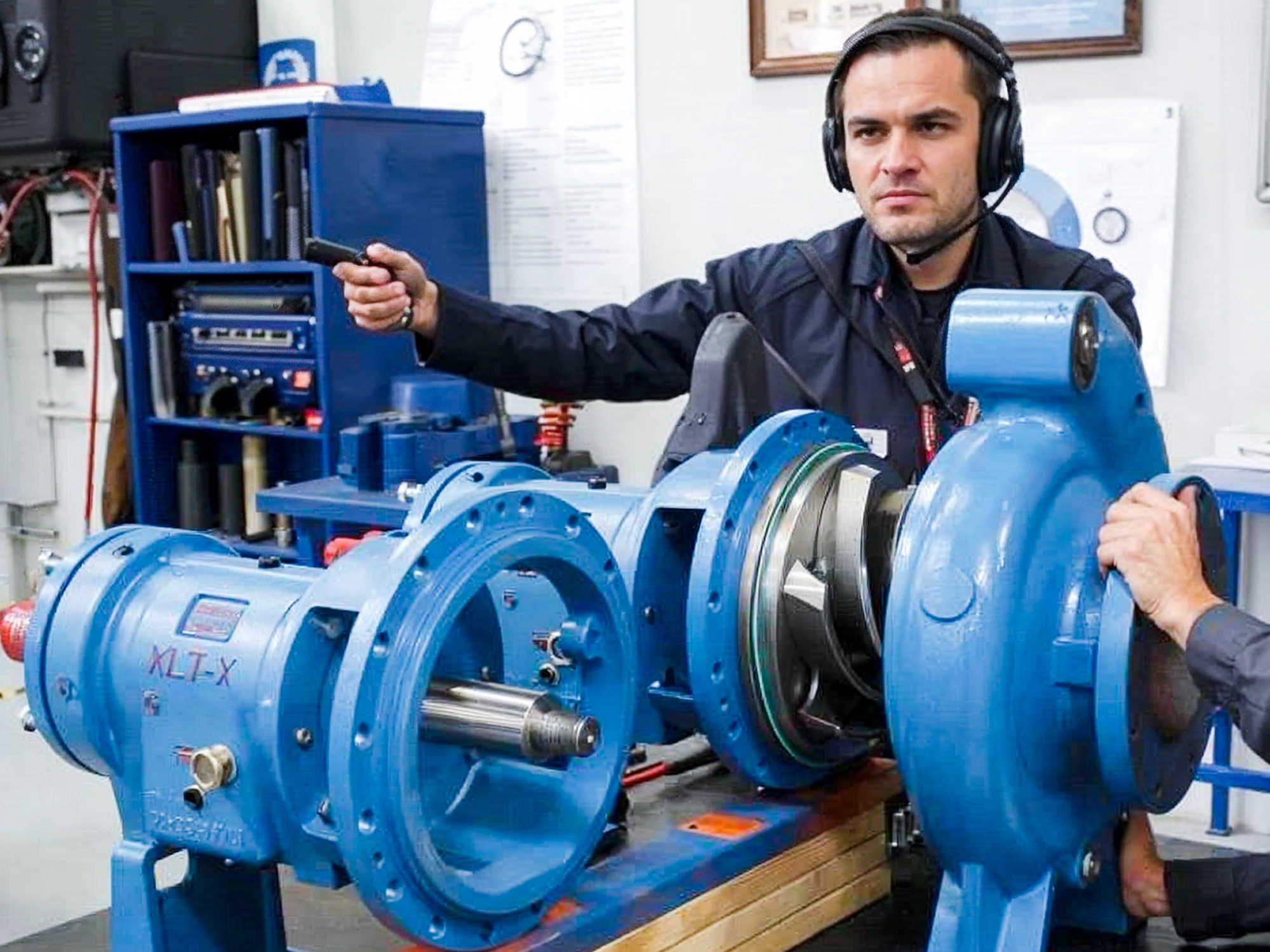 Technician managing pump setup near tank yard